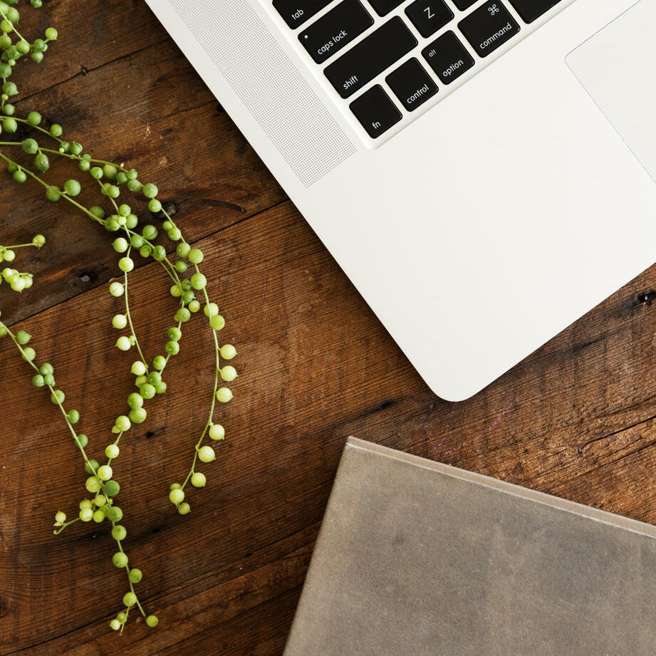 A laptop and notebook sitting on a desk